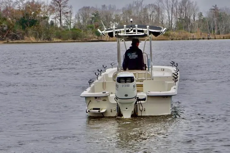 Slide: The Image of 2017 Carolina Skiff 238 DLV boat on calm water, rear view with outboard motor. - 4