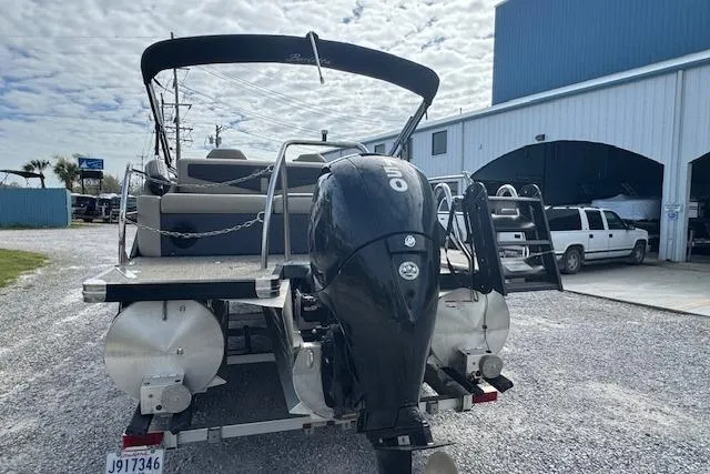 Slide: The Image of 2022 Barletta Cabrio 22UC pontoon boat with outboard motor, parked near a warehouse. - 10