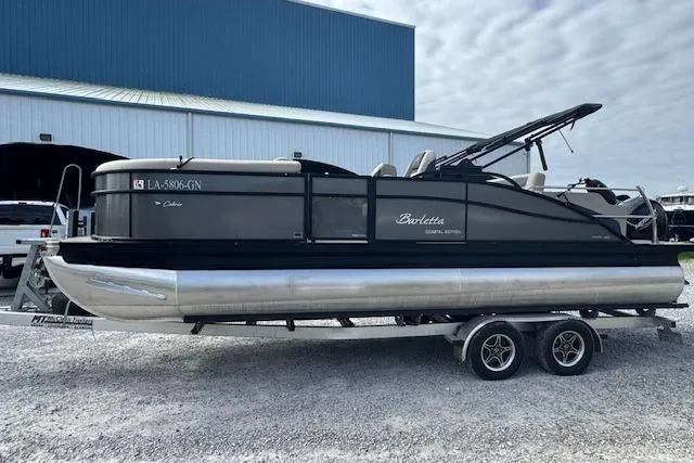 Slide: The Image of 2022 Barletta Cabrio 22UC pontoon boat on trailer, parked outdoors. - 7