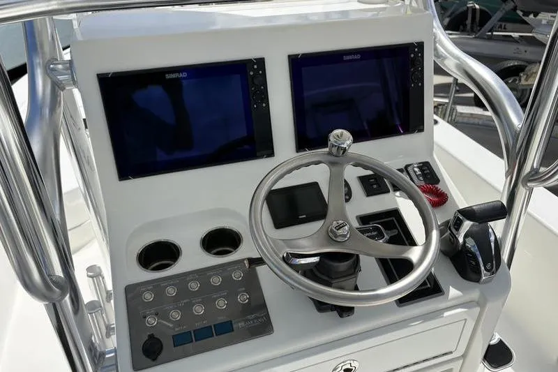 Slide: The Image of 2022 Islamorada 24 Morada boat dashboard with dual Simrad displays and steering wheel. - 10