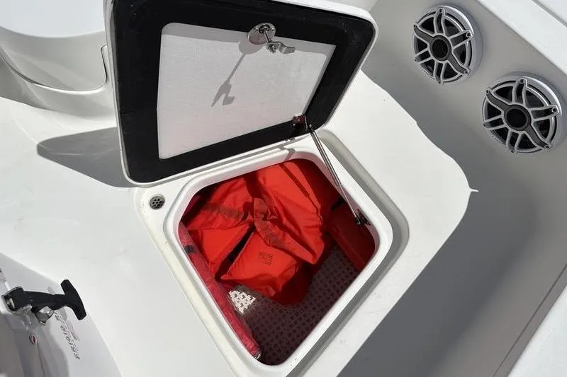Slide: The Image of Open storage compartment on 2022 Islamorada 24 Morada boat with red life jackets inside. - 21