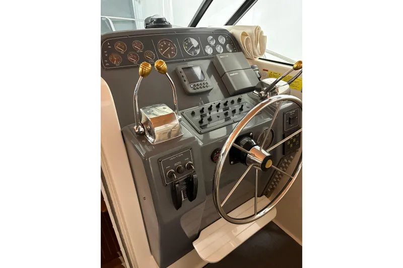 Slide: The Image of 1994 Tiara Yachts 3100 Open helm with steering wheel and control panel. - 21