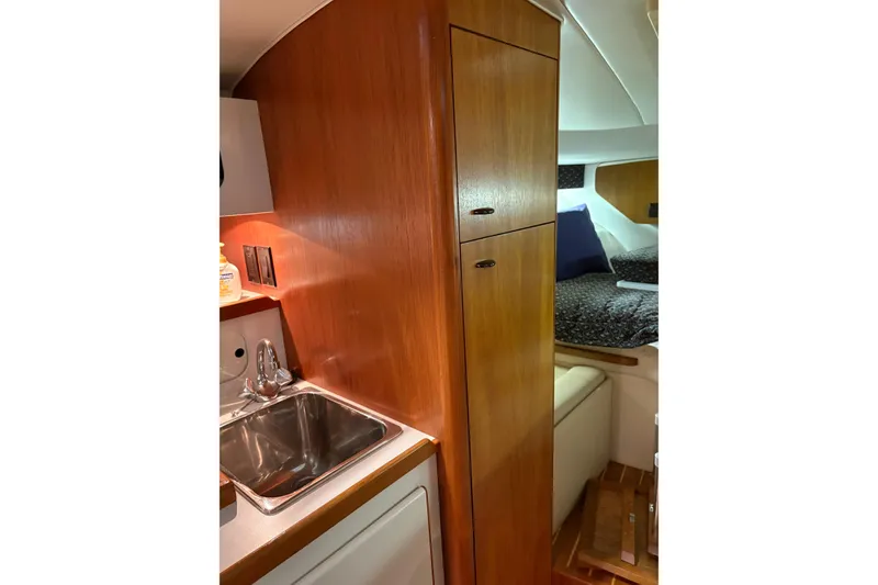 Slide: The Image of 1994 Tiara Yachts 3100 Open cabin interior with cozy bed and porthole window. - 34
