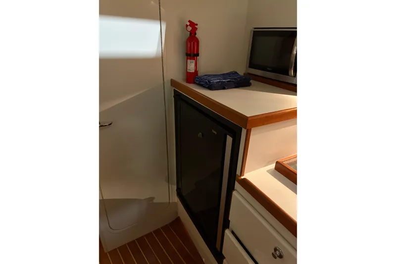 Slide: The Image of 1994 Tiara Yachts 3100 Open galley with sink, storage, and microwave. - 35