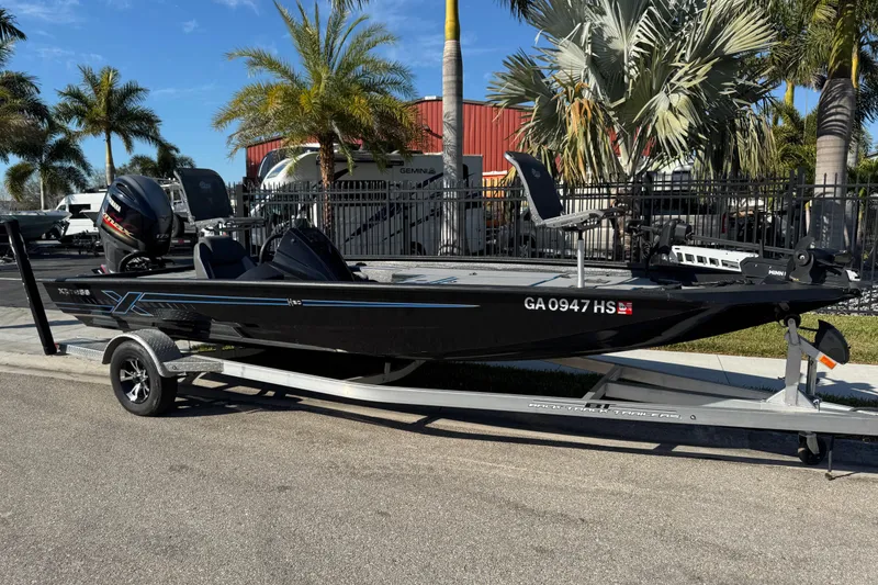 The Image of 2025 Express H20 boat on trailer, parked near palm trees and a red building. - 1