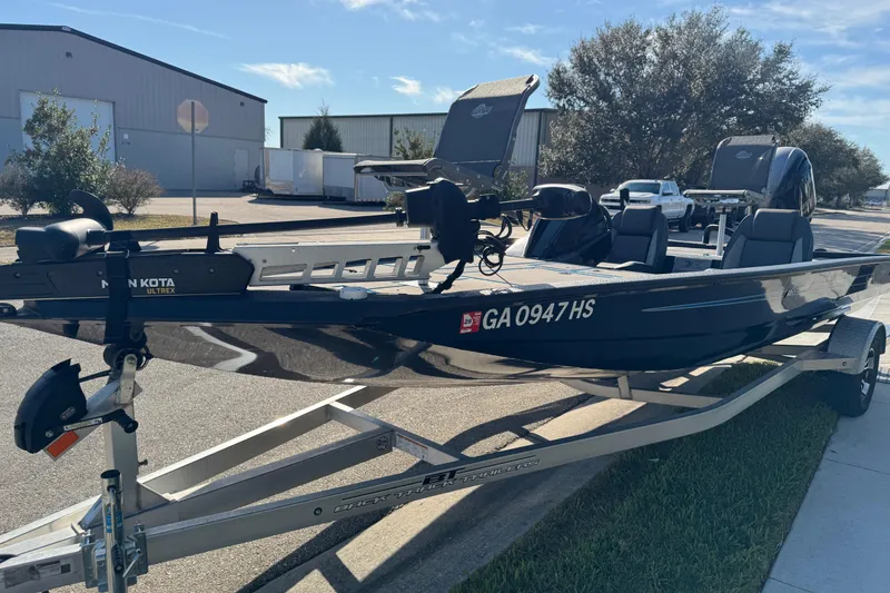 Slide: The Image of 2025 Express H20 boat on trailer, parked outdoors, featuring Minn Kota Ultrex motor. - 14