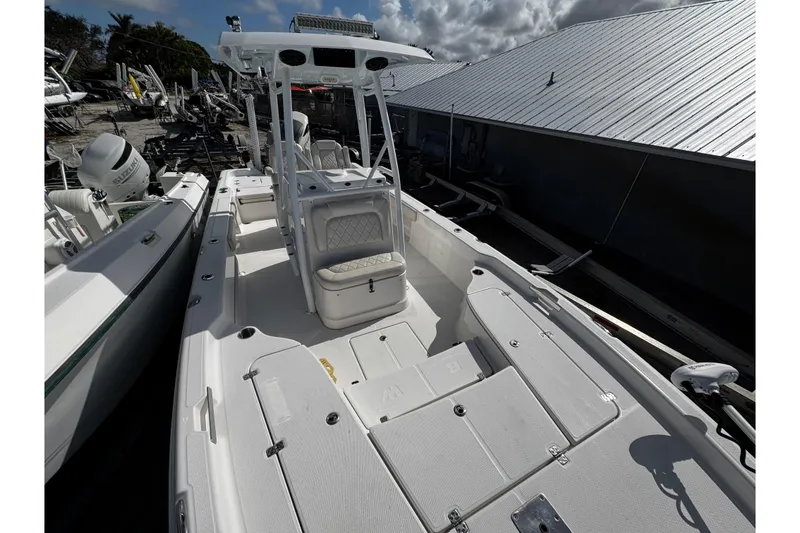 Slide: The Image of 2021 Blue Wave 2600 PureBay boat with spacious deck and seating, docked outdoors. - 11