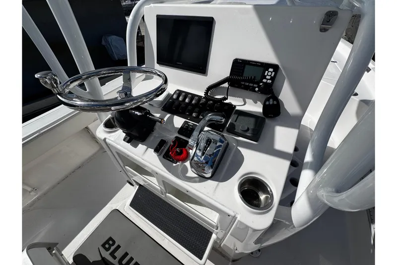 Slide: The Image of 2021 Blue Wave 2600 PureBay boat console with steering wheel and control panel. - 16