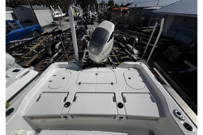 Slide: The Image of 2021 Blue Wave 2600 PureBay boat with Suzuki engine, docked with trailers in background. - 20