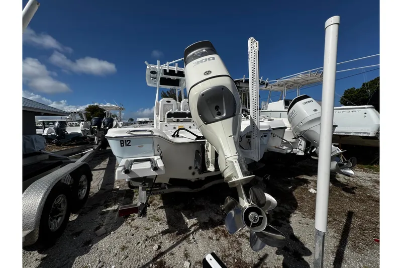 Slide: The Image of 2021 Blue Wave 2600 PureBay boat with dual outboard motors in a marina setting. - 4