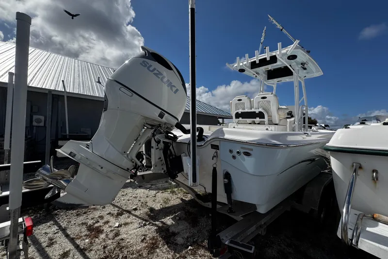 Slide: The Image of 2021 Blue Wave 2600 PureBay boat with Suzuki outboard motor, parked outdoors. - 5
