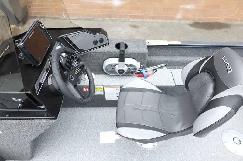 Slide: The Image of 2026 Lund 1650 Angler SS boat interior with steering wheel and seat. - 18