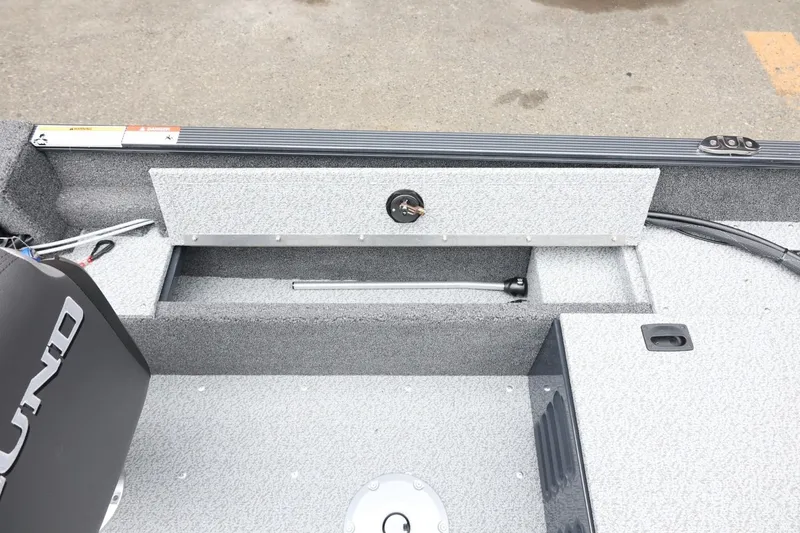 Slide: The Image of 2026 Lund 1650 Angler SS boat interior with storage compartment and motor detail. - 26