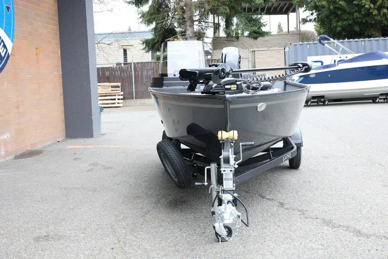 Slide: The Image of 2026 Lund 1650 Angler SS boat on trailer, parked outdoors near a building. - 3