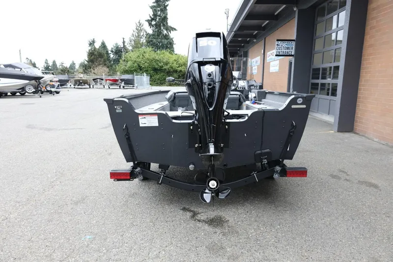 Slide: The Image of 2026 Lund 1650 Angler SS boat with outboard motor in a dealership lot. - 7
