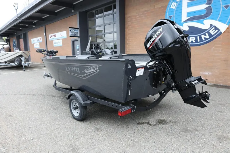 Slide: The Image of 2026 Lund 1650 Angler SS boat with Mercury engine on trailer outside dealership. - 8