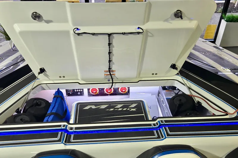 Slide: The Image of Open engine compartment of 2025 MTI 440 boat with visible components and storage. - 17