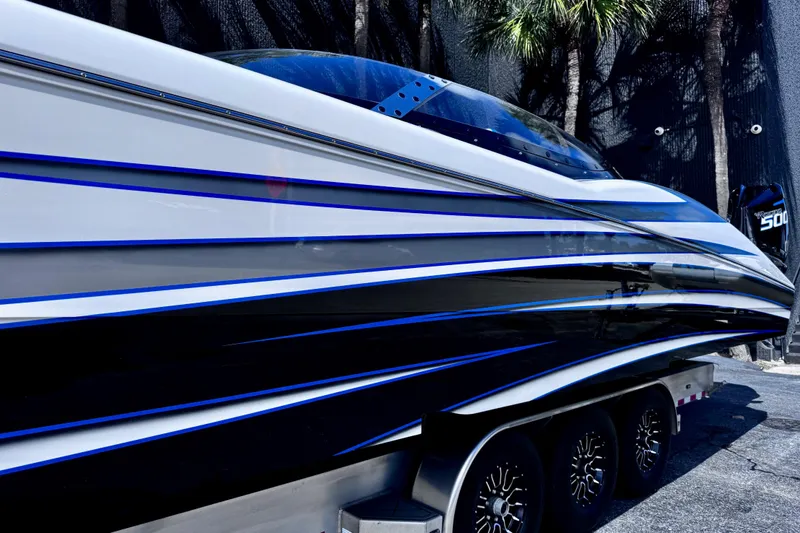 Slide: The Image of 2025 MTI 440 boat with sleek blue and white design on a trailer. - 4