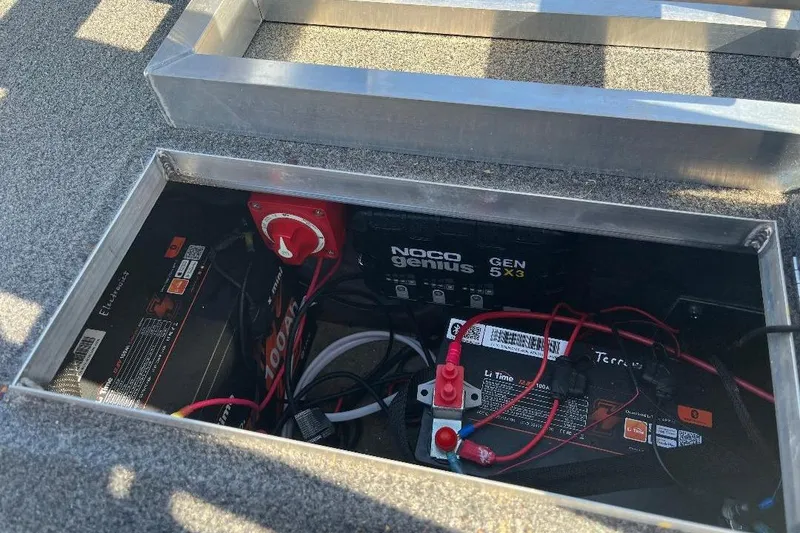 Slide: The Image of Battery compartment of 2024 CustomBilt Pondtoon 1672 with NOCO Genius charger and wiring. - 8