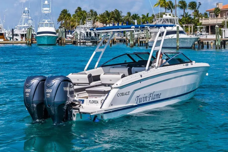 Slide: The Image of 2022 Cobalt R8 Outboard boat with twin Yamaha engines in a marina setting. - 12