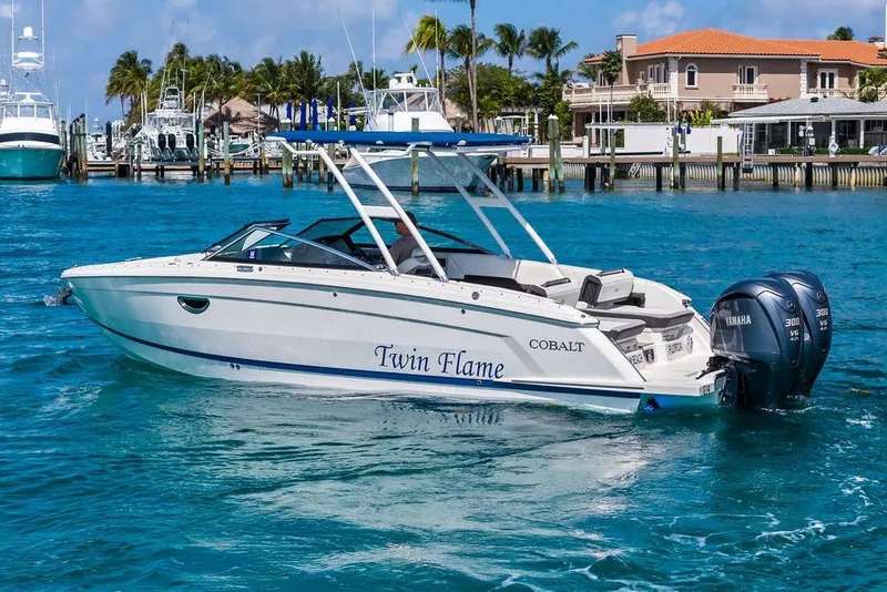 Slide: The Image of 2022 Cobalt R8 Outboard boat on clear blue water near a marina. - 13
