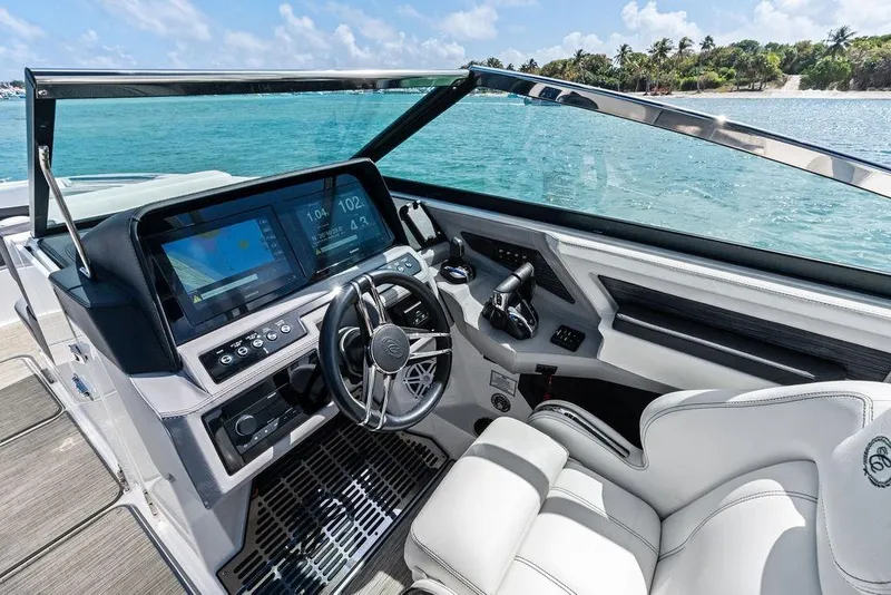 Slide: The Image of 2022 Cobalt R8 Outboard boat cockpit with modern controls and scenic ocean view. - 5