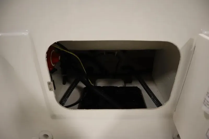 Slide: The Image of 2025 Bayliner Element E18 storage compartment with wiring and components visible. - 15