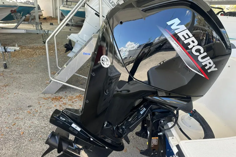 Slide: The Image of 2025 Bayliner Element E18 with Mercury outboard motor in a boatyard setting. - 18
