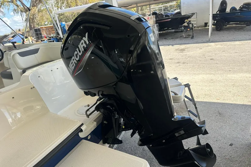 Slide: The Image of 2025 Bayliner Element E18 with Mercury outboard motor in a marina setting. - 19