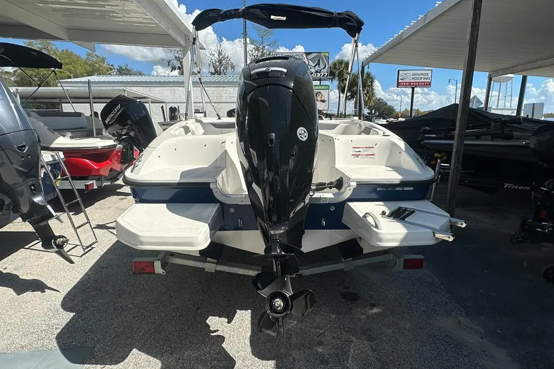 Slide: The Image of 2025 Bayliner Element E18 boat with outboard motor, parked under a canopy. - 3