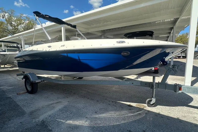 Slide: The Image of 2025 Bayliner Element E18 boat on trailer under canopy, blue and white design. - 4