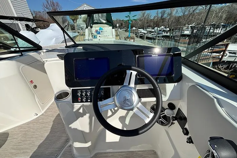 Slide: The Image of 2026 Sea Ray SDX 250 Outboard helm with dual Simrad displays and steering wheel. - 15