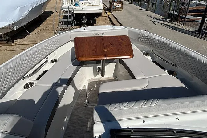 Slide: The Image of 2026 Sea Ray SDX 250 Outboard boat interior with seating and wooden table. - 23