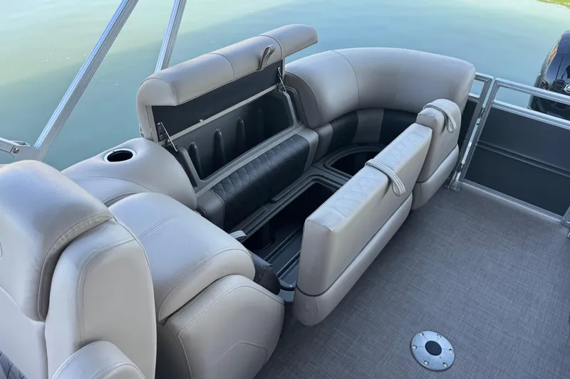 Slide: The Image of 2024 Sun Tracker Party Barge 24 DLX interior seating with storage compartments. - 10
