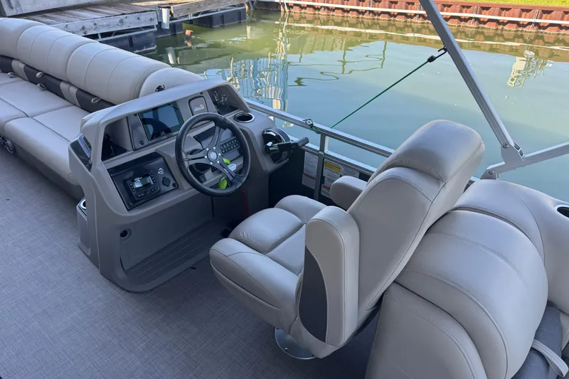 Slide: The Image of 2024 Sun Tracker Party Barge 24 DLX interior with steering console and seating. - 11