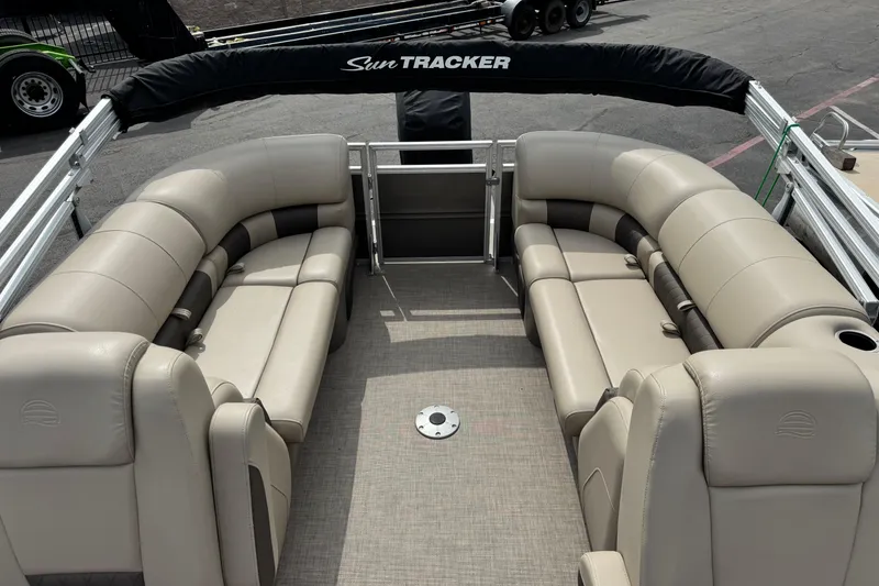 Slide: The Image of 2024 Sun Tracker Party Barge 24 DLX interior with beige seating and spacious layout. - 3