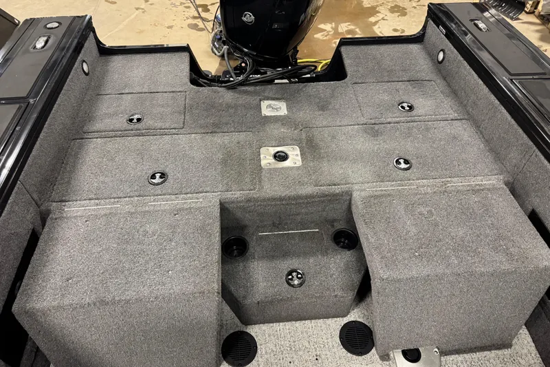 Slide: The Image of 2024 Tracker Targa V-18 Combo boat interior with carpeted deck and storage compartments. - 13