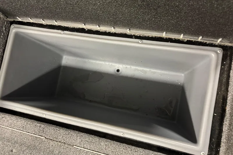 Slide: The Image of 2024 Tracker Targa V-18 Combo storage compartment, empty and clean, with a gray interior. - 15