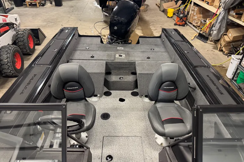 Slide: The Image of 2024 Tracker Targa V-18 Combo boat interior with dual seats and storage compartments. - 18
