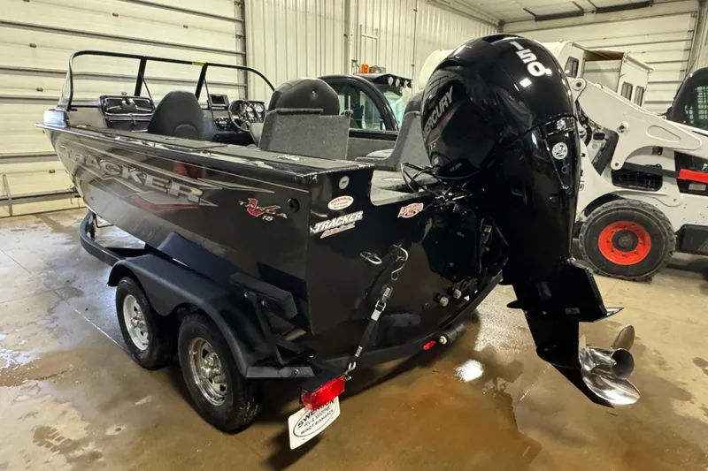 Slide: The Image of 2024 Tracker Targa V-18 Combo boat with Mercury engine in a garage setting. - 4