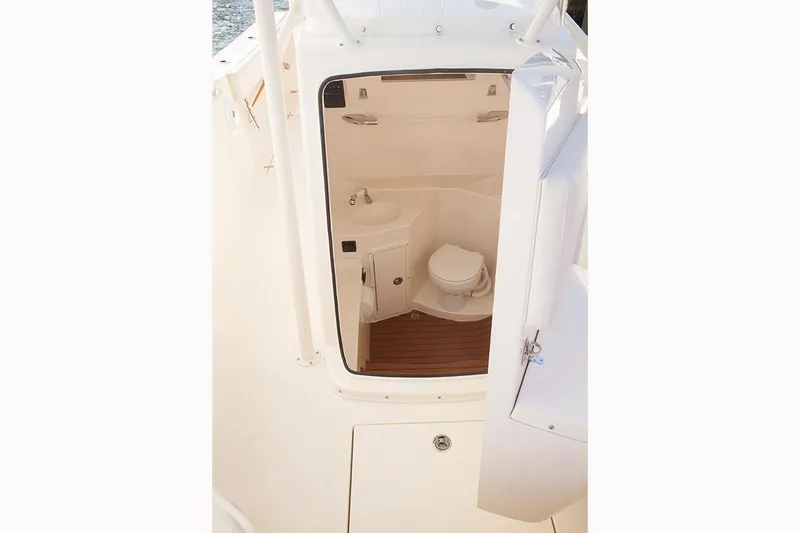 Slide: The Image of Manufacturer Provided Image: 2017 Cobia 277 Center Console boat interior with a compact marine toilet. - 19