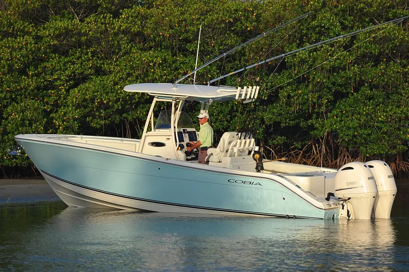 Slide: The Image of Manufacturer Provided Image: 2017 Cobia 277 Center Console boat on calm water near lush greenery. - 5