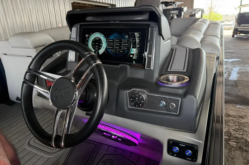 Slide: The Image of 2020 Ranger 2300LS boat dashboard with steering wheel, digital display, and cup holder. - 20