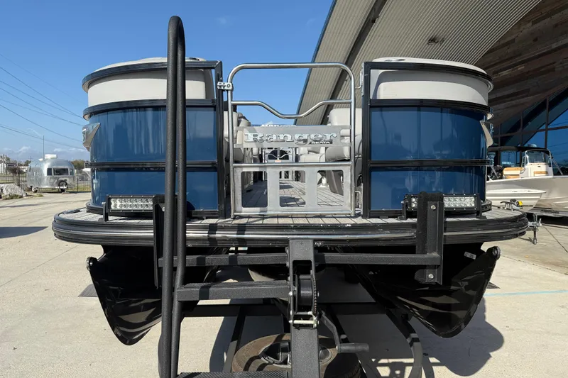 Slide: The Image of 2020 Ranger 2300LS pontoon boat, blue and white, docked at a marina. - 3