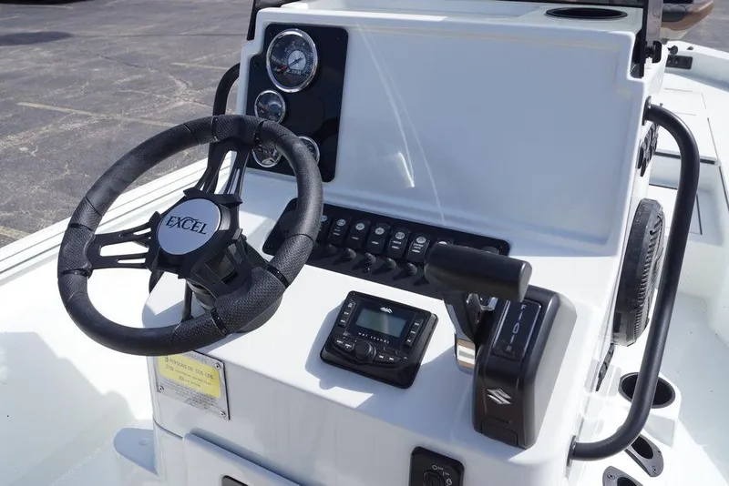 Slide: The Image of 2026 Excel 230 Bay Pro Elite boat dashboard with steering wheel and controls. - 11
