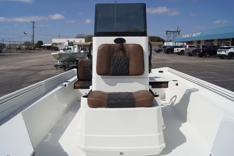 Slide: The Image of 2026 Excel 230 Bay Pro Elite boat with brown seating, parked outdoors. - 6