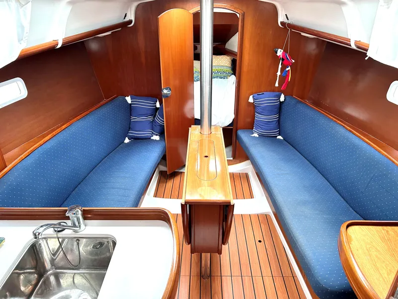 Slide: The Image of 2005 Beneteau 323 sailboat with green canopy on calm waters. - 11