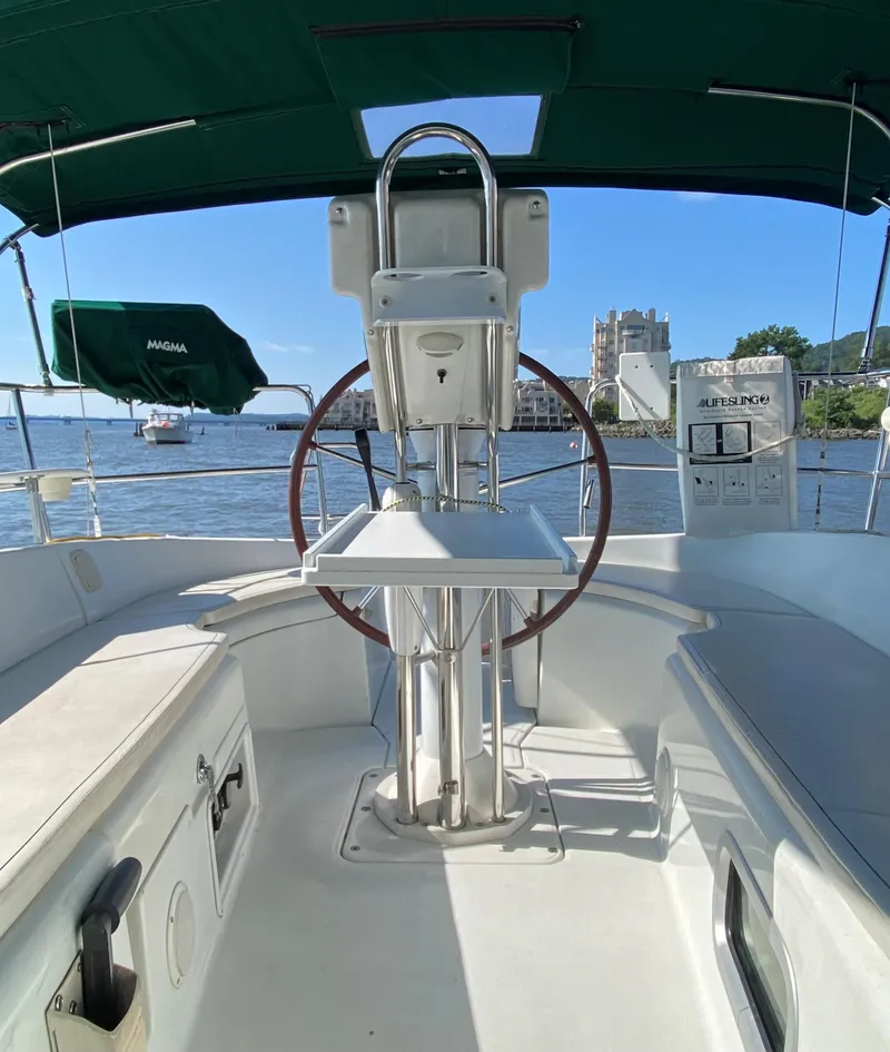 Slide: The Image of 2005 Beneteau 323 sailboat docked in marina, featuring green canopy and sleek design. - 4