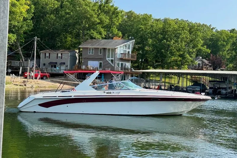 The Image of 1995 Sea Ray 380 Sun Sport boat cruising on a lake near waterfront homes. - 0