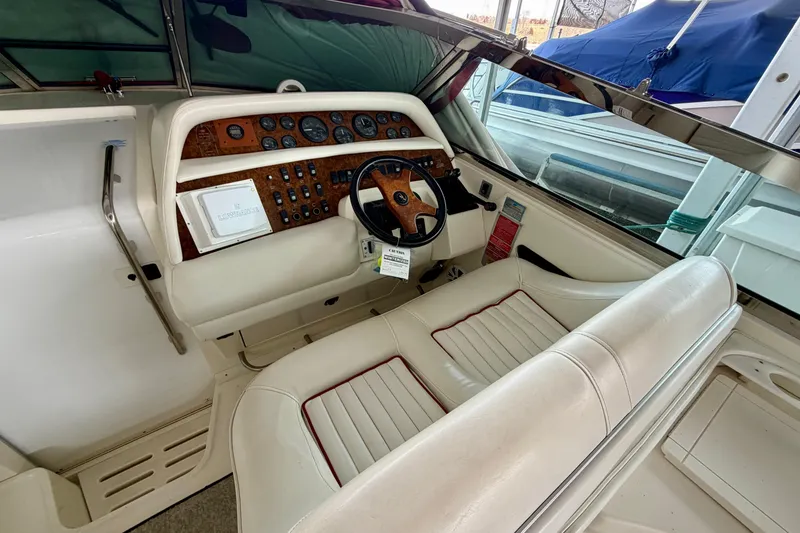 Slide: The Image of 1995 Sea Ray 380 Sun Sport cockpit with white leather seating and wood-accented dashboard. - 15